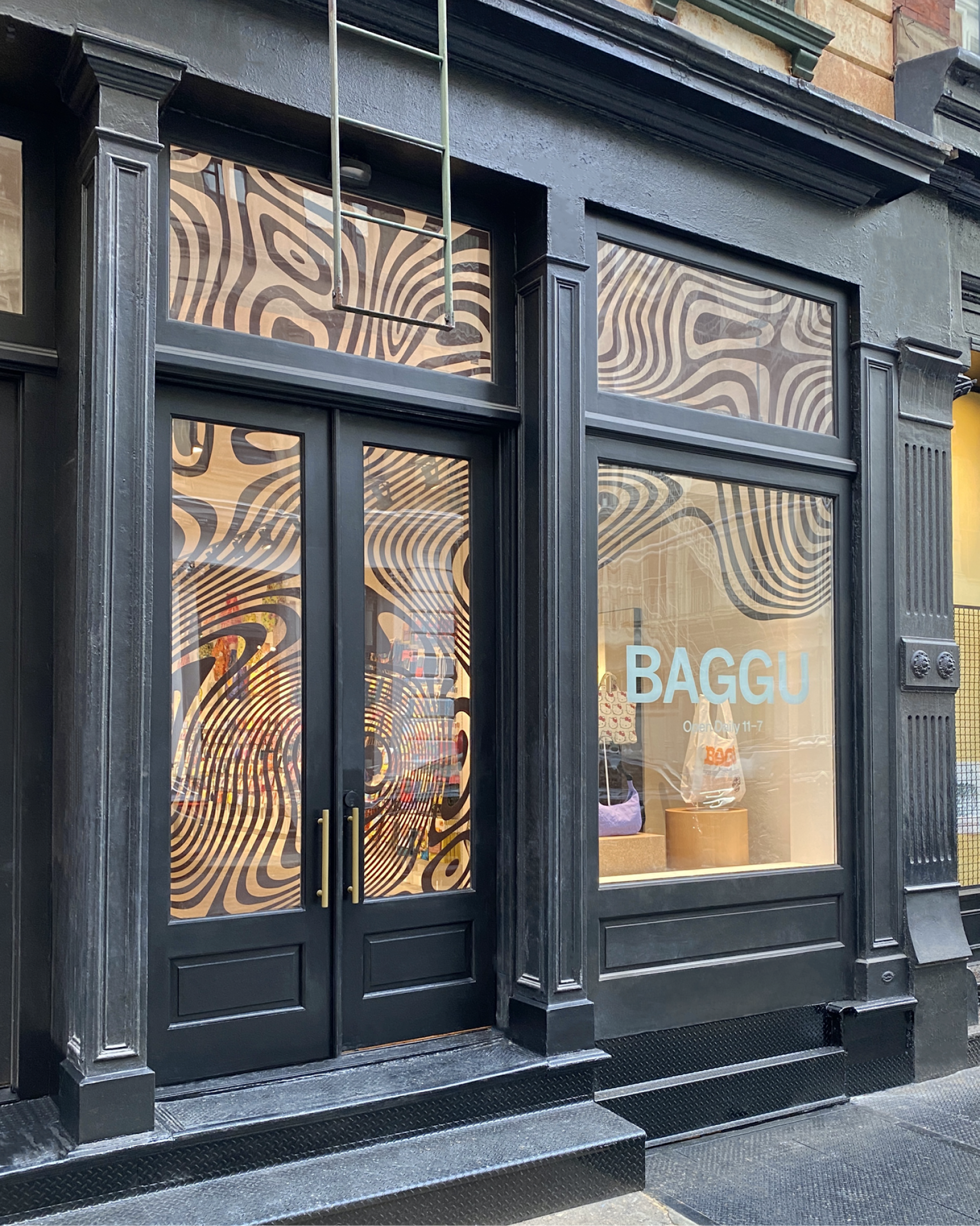 Two people stand outside of the Baggu SoHo store in New York City.